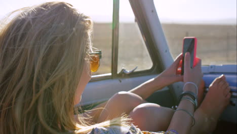 woman taking a selfie in a vintage car during a road trip