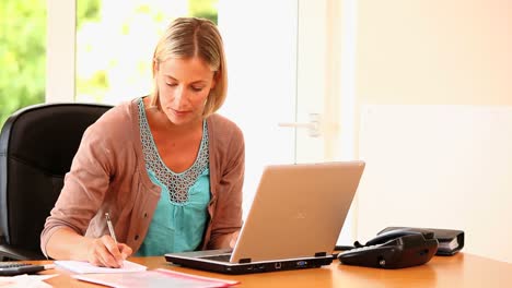 Junge-Frau,-Die-An-Einem-Laptop-Arbeitet-Und-Einen-Anruf-Entgegennimmt