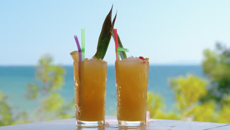 ice cube falling into the glass with fruit cocktail