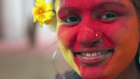 indian women close-up of face smeared with bright holi colors