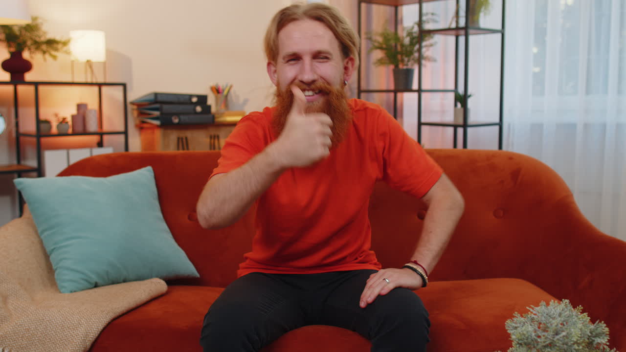 행복 한 젊은이 는 긍정적 인 징조, 좋은 소식 처럼 엄지 손가락 을 올려 놓고 카메라 를 긍정적 으로 바라보고 있다