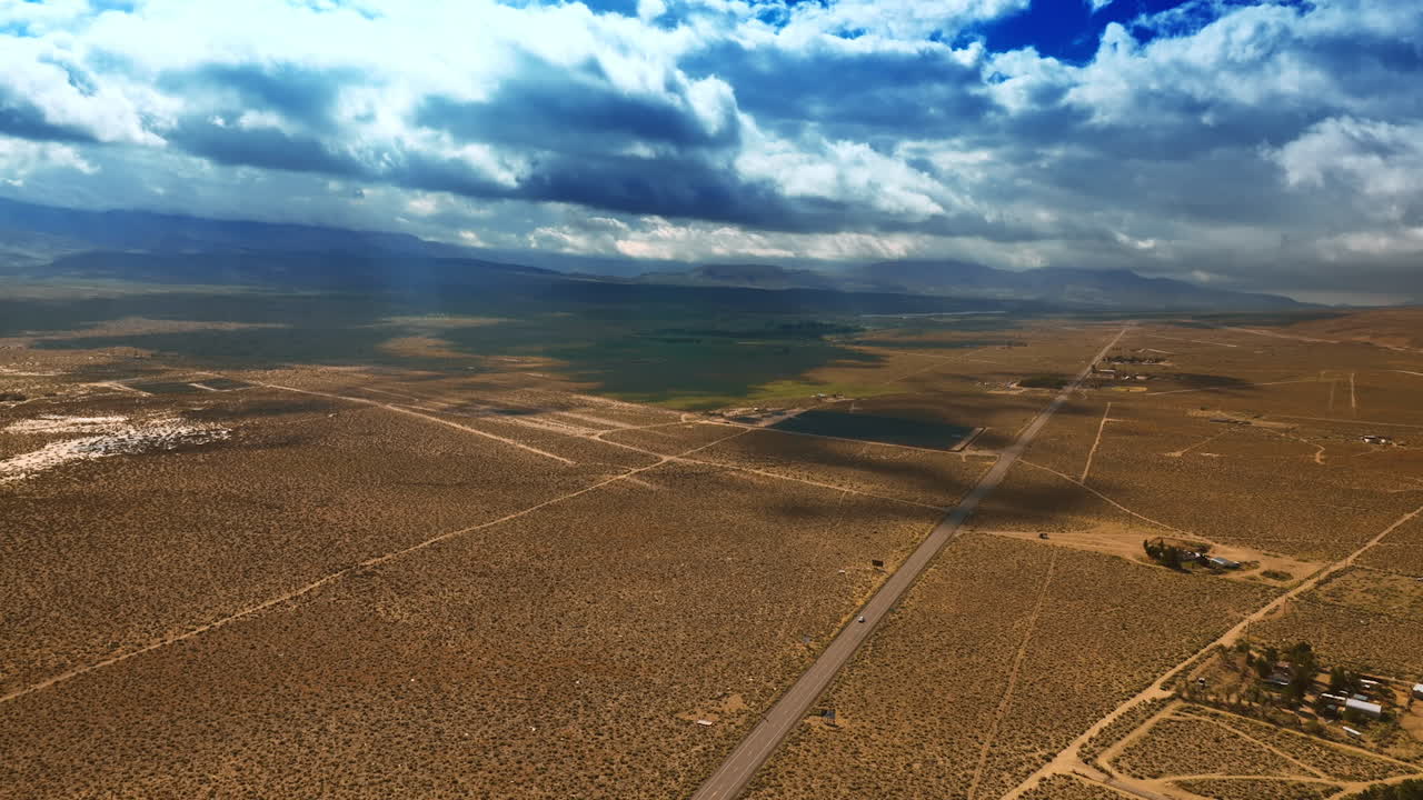 Vast desert crossed by highways and roads. Thick cloudscape covering the landscape from the sun. Aerial view.
