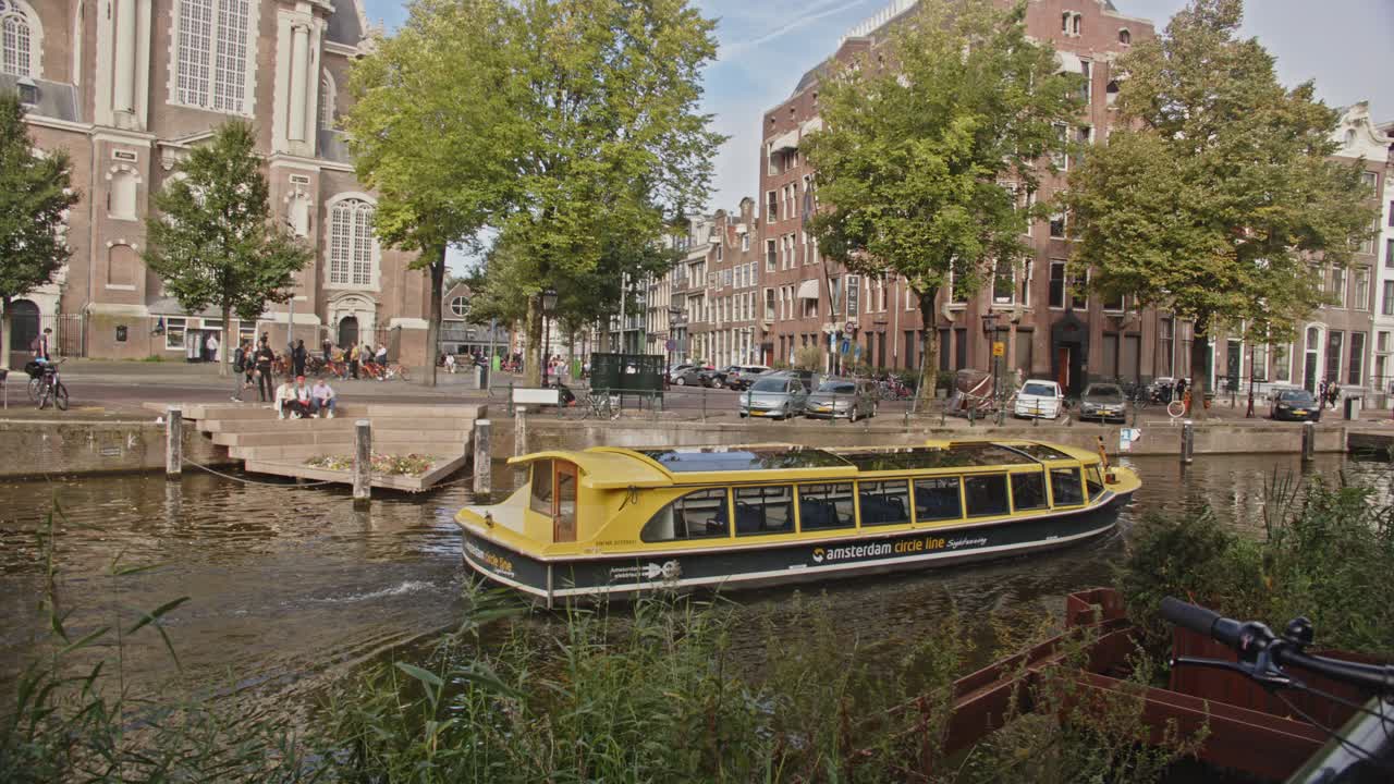 암스테르담 의 전기 관광 보트 가 암스테르담 시내 의 운하 를 항해 하고 있다