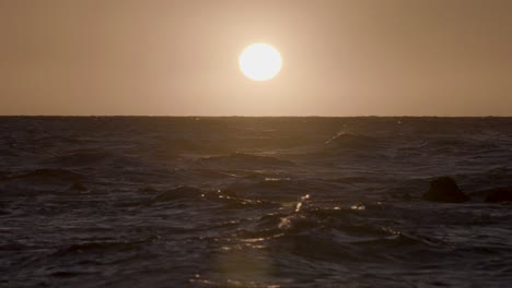 Aufnahme-Vom-Strand-In-Hawaii-Mit-Blick-Auf-Das-Meer,-Während-Die-Wellen-Vor-Der-Untergehenden-Sonne-Brechen