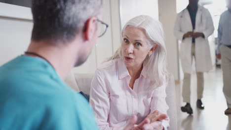 Doctor-Welcoming-To-Senior-Female-Patient-Being-Admitted-To-Hospital