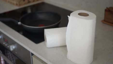 paper towels and a pan on a kitchen counter