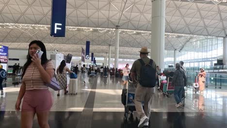 travelers navigating through hong kong airport terminal