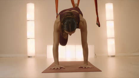 fit woman stretching body before yoga training. girl doing handstand in studio