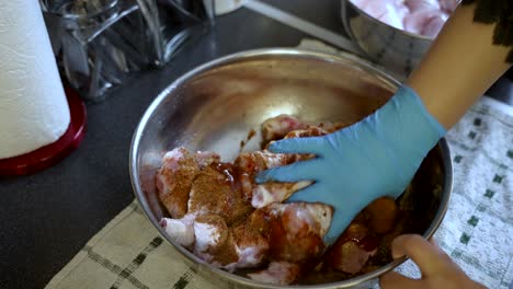 asian cook hand marinates halal chicken in spicy aromatic sauce in kitchen slow motion