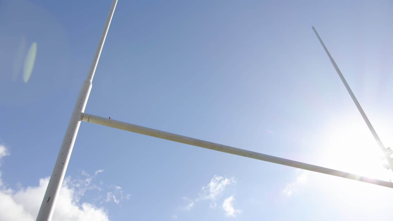 Rugby goalposts, clear blue sky on sunny day, symbolizing sports and fitness, on field, copy space