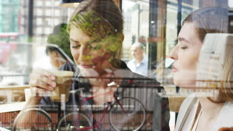 two woman friends sharing coffee in cafe