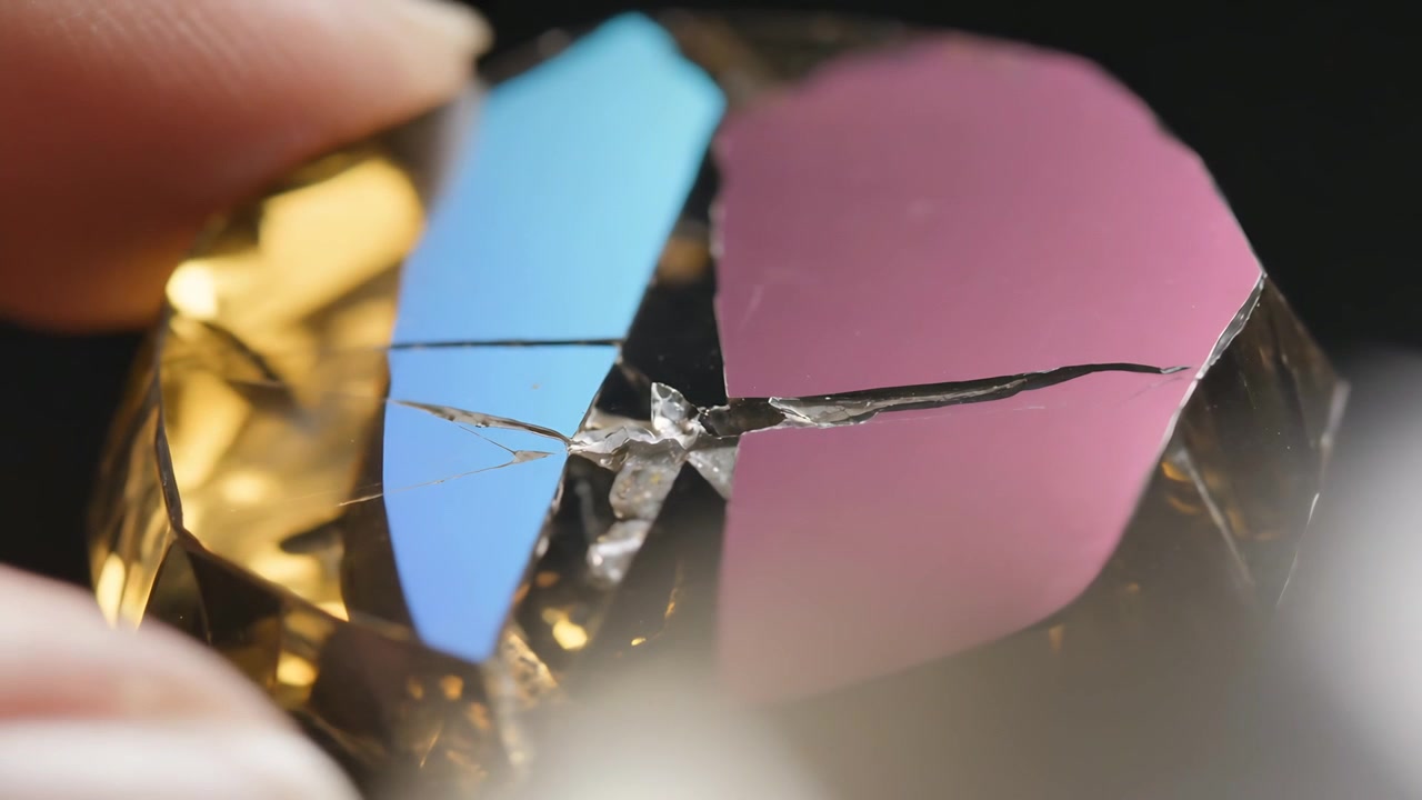 Touching human fingertip entering frame, pressing gemstone at studio, inspecting dichroic crack