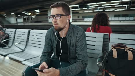 man using smartphone at train station