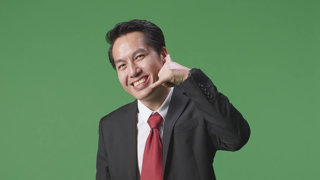 사업복을 입은 남자가 전화 통화를 하는 몸짓