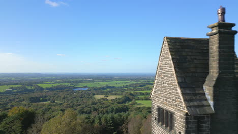 english countryside in autumn with lonely stone tower building on hilltop reveal, close fly pastrivington, lancashire, england, uk