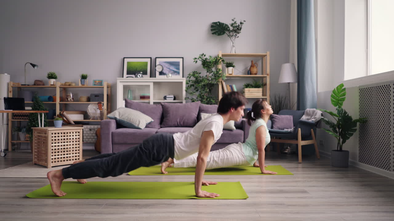 夫婦が自宅でヨガを練習している