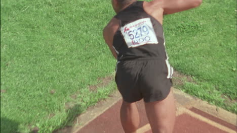 a man runs and  throws a javelin