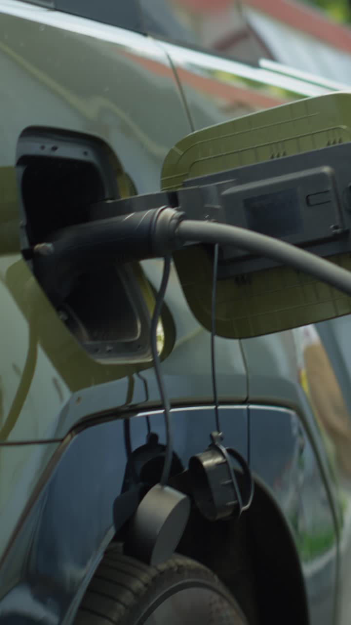 Vertical video Eco friendly electric car battery being recharged, close up