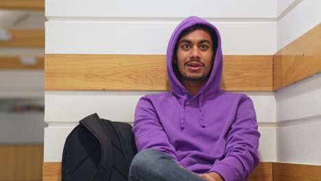 sri lankan man wearing vibrant purple hoodie having conversation behind camera