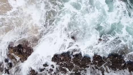 Drohnenantenne-über-Meereswellen,-Die-Den-Strand-Krachen-Lassen