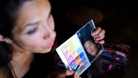 female video blogger applying eyeshdow in front of mirror 4k