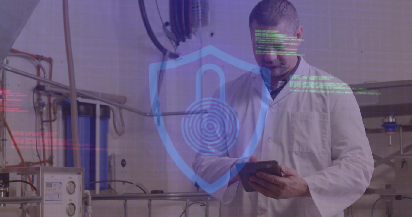 A male worker is using a digital tablet in a factory
