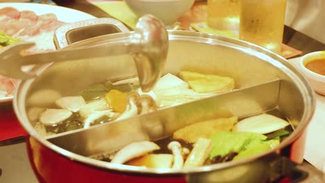 simmering hotpot with vegetables and broth