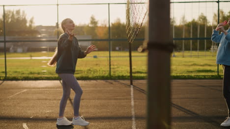 volleyball players practicing with sunlight creating warm glow, background features open field with blurry view of someone pushing bicycle and other people walking