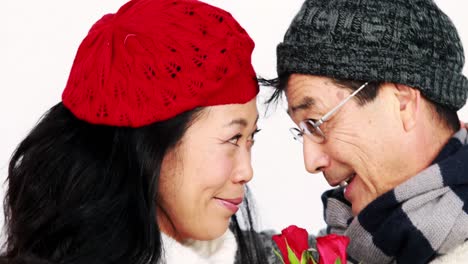 mature asian couple holding roses