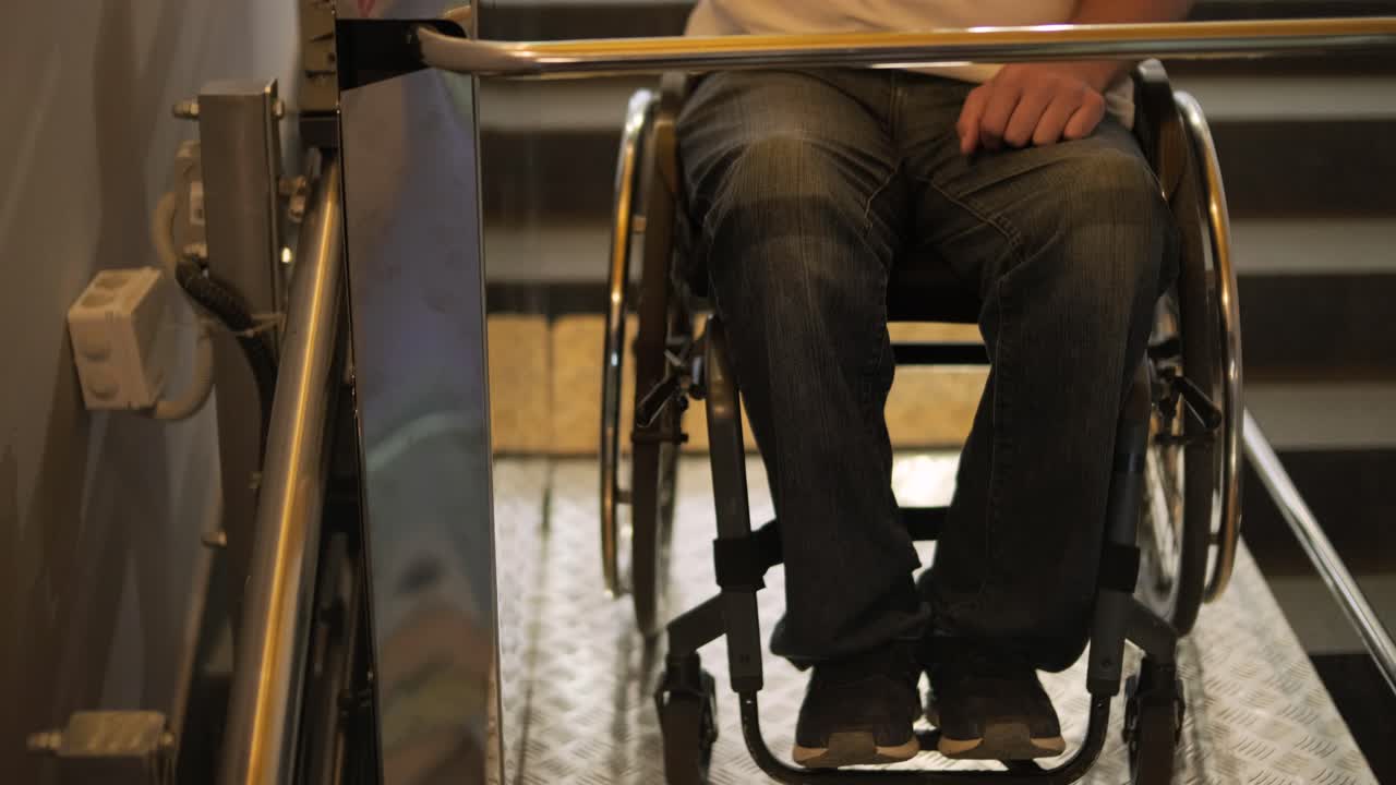 신체 장애를 가진 사람을 위한 엘리베이터: 체어에 앉은 사람은 엘리베이트를 사용한다.