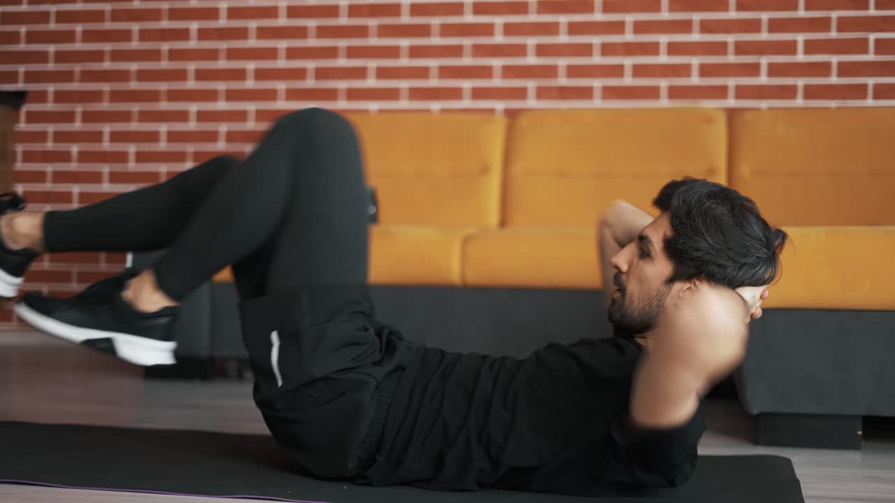 hombre entrenando en el tapete en casa, haciendo ejercicio en bicicleta en la espalda