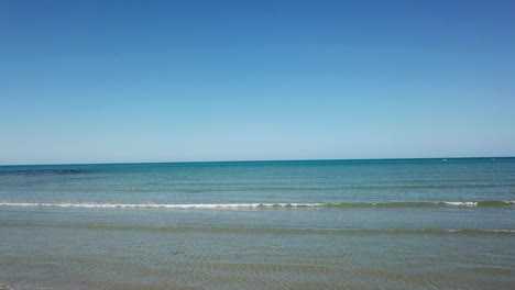 aerial: drone moving over a sandy beach towards the ocean in cape tribulation, far north queensland