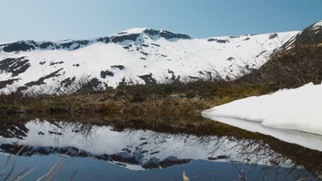 el agua refleja las montañas de nieve en el paisaje noruego