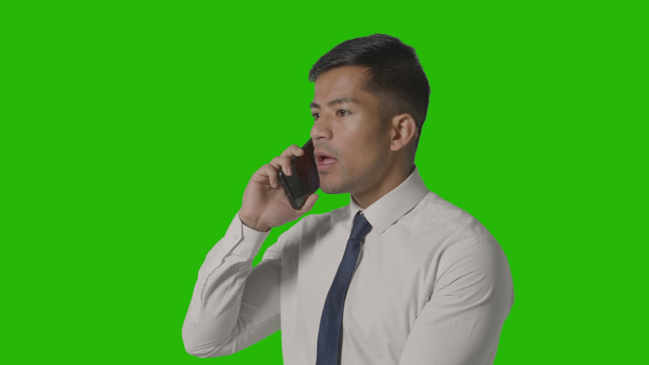 녹색 화면 2에 대 한 휴대 전화에 대 한 셔츠와 넥타이에 화난 사업가의 스튜디오 샷