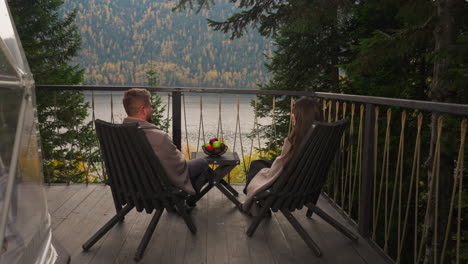 couple relaxing on a lakeside balcony in autumn