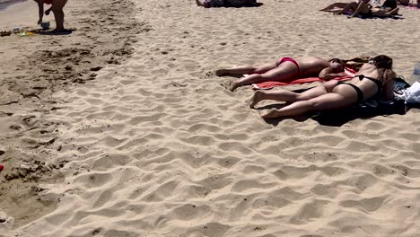 two girls enjoy a fantastic sunny day at guincho beach in cascais, chatting and having a great time