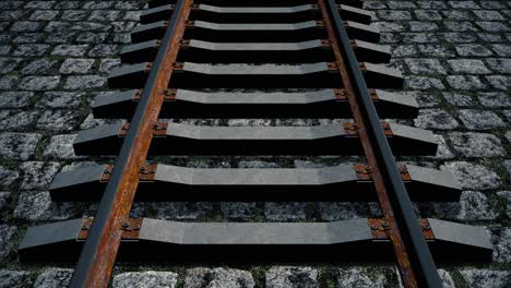 an aerial view over an old rusty railroad track laid down on cobblestones - seamless looping