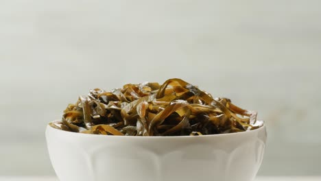 japanese wakame sea weed laminaria chuka fermented food. close-up on a detail of hiyashi wakame chuka or seaweed salad or seaweed with sesame seeds on a plate. top view. seafood background.