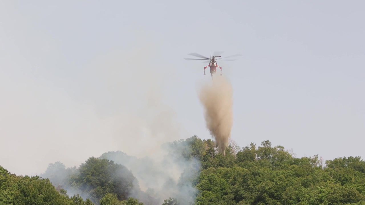 Un elicottero Sikorsky S-64 Skycrane che sgancia acqua su un incendio boschivo. Rocca di Mezzo, regione Abruzzo. Italia. Estate 2026