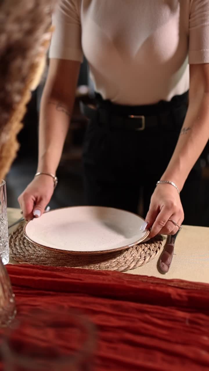 Woman's Hands Placing a Plate on a Rustic Dining Table