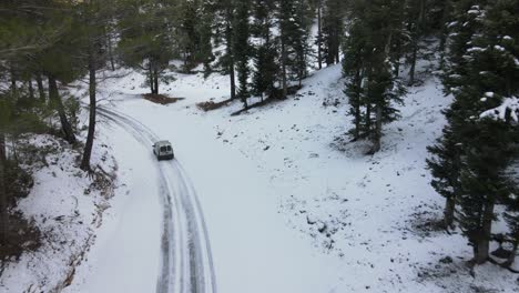 car driving on snowy forest road