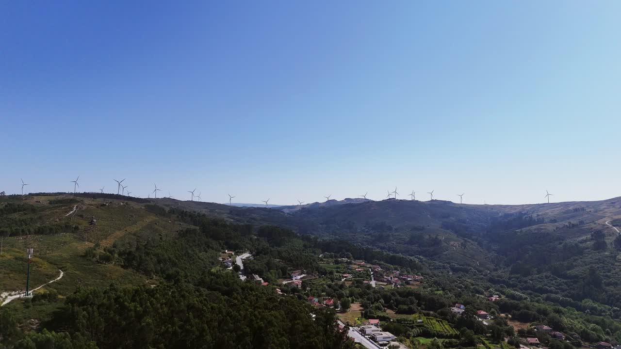 aérea - valle del norte de portugal, turbinas eólicas que bordean la cordillera bajo un cielo azul claro