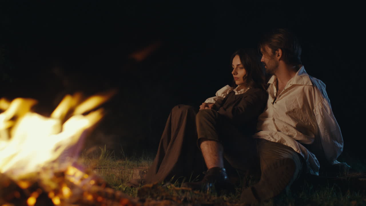 Romantic Couple by a Campfire at Night