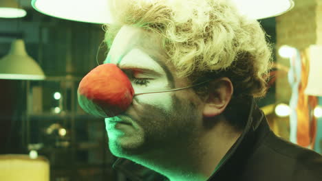 clown posing for camera with hanging lamp above head