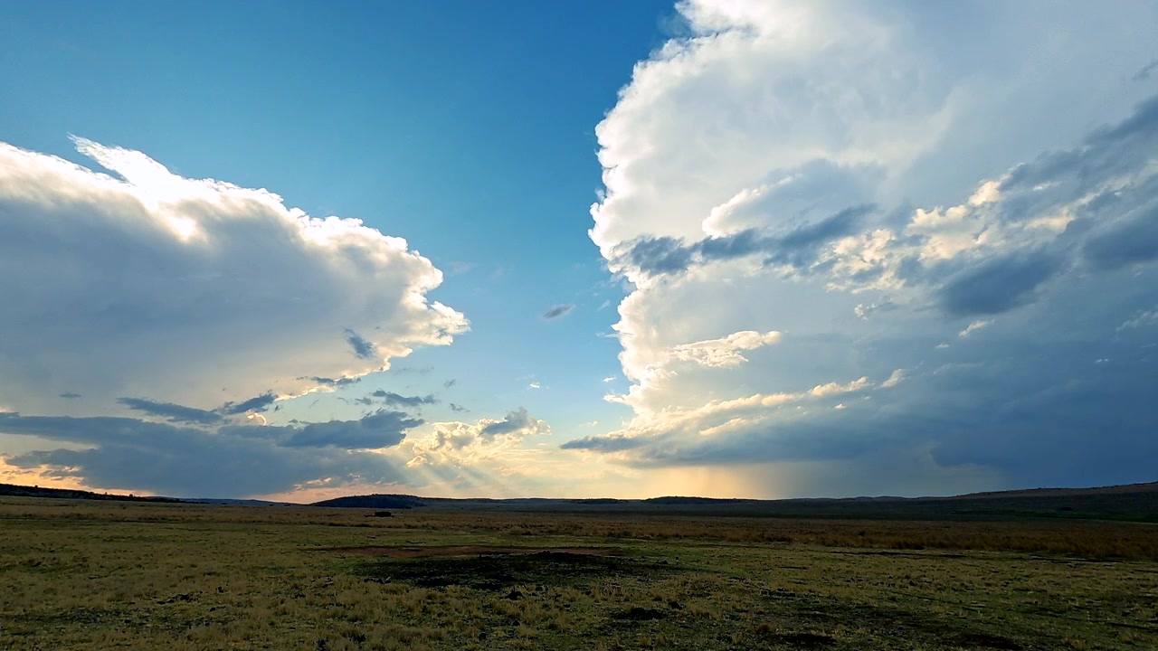 Timelapse del tramonto mentre il sole scompare dietro nuvole temporalesche in formazione su un paesaggio arido