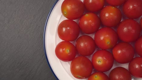 wet cherry tomatoes on a white plate with a blue border