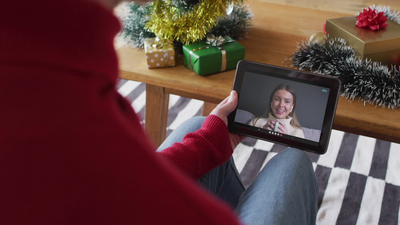 hombre albino agitando y usando la tableta para la llamada de video de navidad con una mujer sonriente en la pantalla