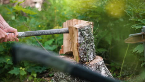 Unrecognizable-man-splits-log-of-birch-wood-in-two-with-axe,-slomo-pan