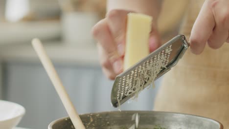 Crop-woman-grating-cheese-for-pasta