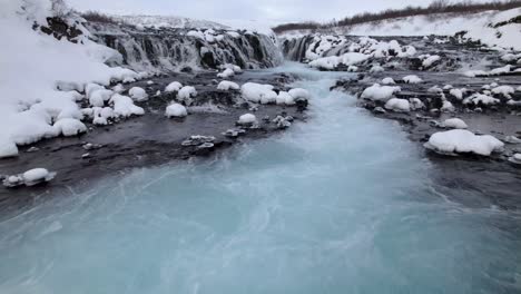 Scenic-waterfall-streaming-from-rocky-cliff-on-winter-day